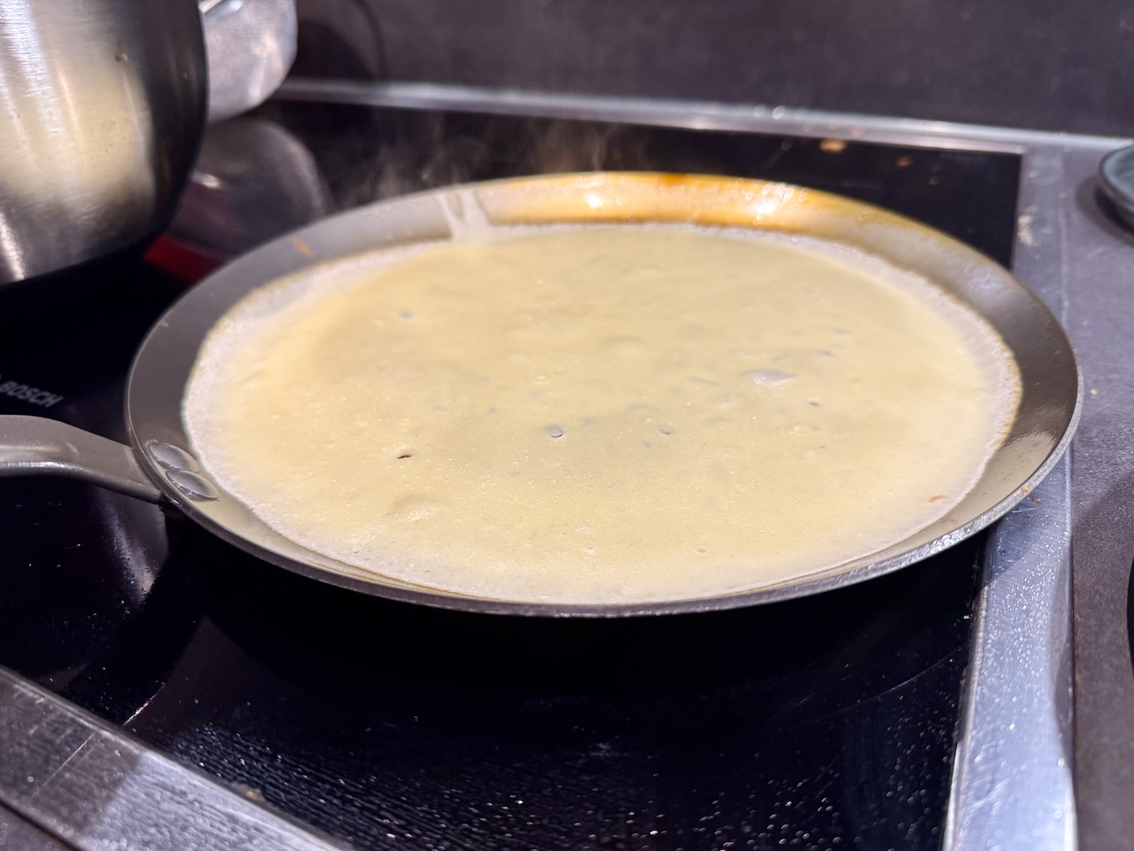 A pancake being made in a de Buyer carbon steel pan
